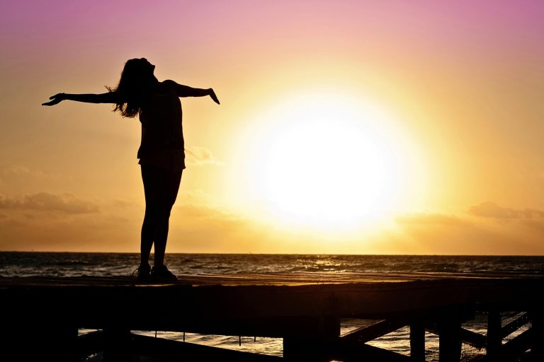 Woman defining what is resilience by rising with the sun