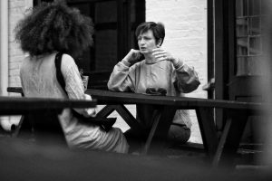 Examples of resilience in building connection. Two friends outside enjoying a chat and coffee