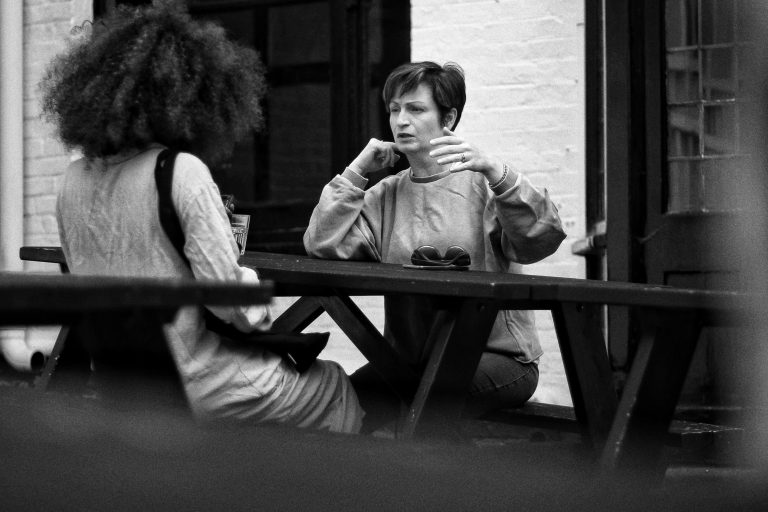 Examples of resilience in building connection. Two friends outside enjoying a chat and coffee
